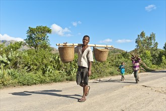 Man of the Antandroy people carrying two baskets on a wooden pole
