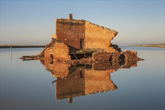 Ruins off a red brick building in a lagoon