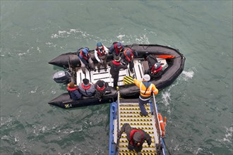 Tourists being helped out of an inflatable boat