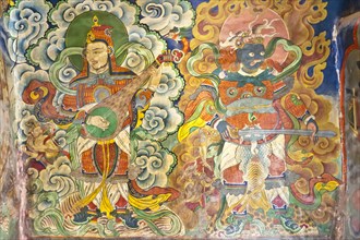 Musicians and demon mural at the entrance of the Tashi Choling Gompa