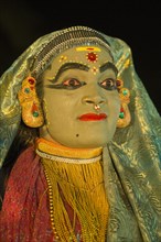 Kathakali dancer in full makeup wearing a costume