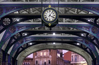 Clock and wrought iron ornaments at dusk