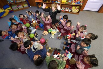 Children sitting on the floor in a circle in a kindergarten