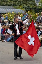 Flag-waver with a Swiss flag at a costume parade