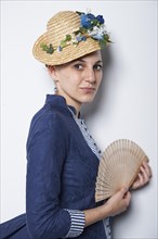 Young woman with hat and fan