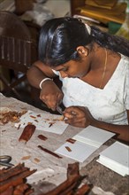 Young woman making wood jewelry
