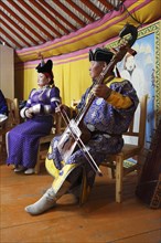 Man in the traditional costume of the Khalkha Mongols playing the horse-head fiddle