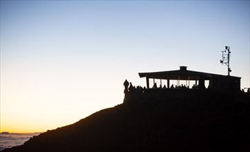 Tourists awaiting the sunrise on the summit of the Haleakala volcano