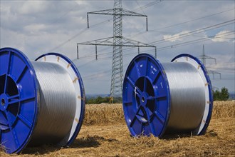 Rolls of conductive cable waiting to be loaded after work on a high-voltage transmission mast