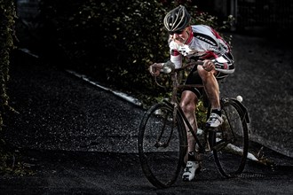 Racing cyclist riding on an old bicycle