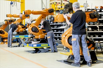 Employees of the robot manufacturer KUKA AG during the assembly of the electrical system of KUKA robots