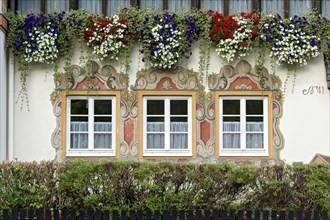 Windows decorated with Luftlmalerei and geraniums