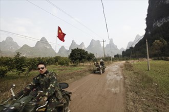 Motorcyclist in front of karst mountains in Yangshuo