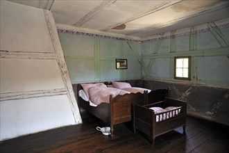 Bedroom with a cot of a half-timbered farmhouse