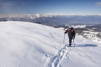 Winter hiker ascending Schwarzhorn Mountain on Jochgrimm Pass