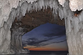 Icicles and ice formations in a cave hanging from ceiling on the shore of frozen Lake Superior