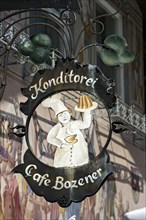 Wrought iron hanging shop sign of the Konditorei Cafe Bozener pastry cafe