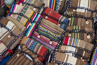 Handmade bags with the traditional patterns of the Quechua Indians are displayed for sale