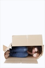 Young woman sleeping in a removal box