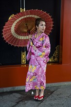 Young woman in kimono and with oil-paper umbrella