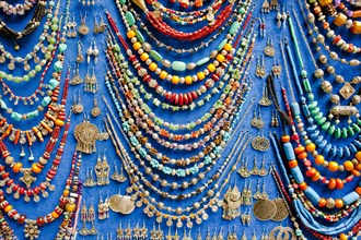 Display of various necklaces and earrings with glass beads and traditional Arab and Berber patterns