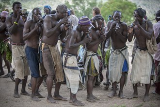 Men of the Koma people dancing and making music