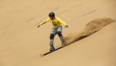 Sand boarding in the dunes of the Namib Desert