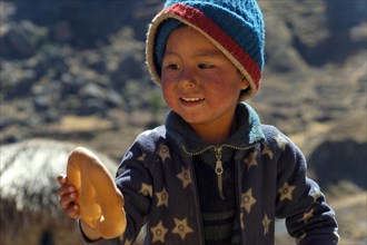 Indian boy holding bread in his hand