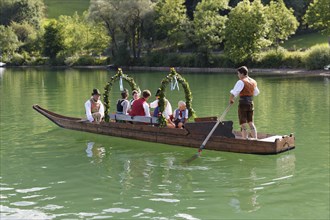 Locals wearing traditional costumes in a decorated wooden Platte boat