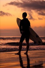 Silhouette of a surfer watching the sunset
