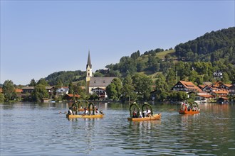 Locals wearing traditional costumes in decorated wooden Platte boats