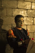 Kathakali dancer in full makeup waiting for his performance