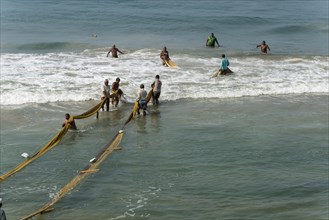 Fishermen pulling fishing nets onto the beach