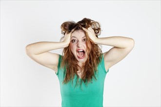 Desperate young woman tearing her hair
