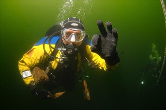 Diver takes wood fragments from a shipwreck