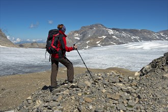 Hiker looking from Pointe de la Plaine Morte over the Plaine Morte Glacier Plateau towards the summit of Wildstrubel Mountain