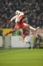 Two players jumping to head a ball