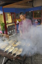 Javanese man grilling fish in a restaurant