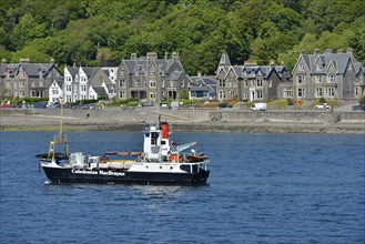 Ship of the Caledonian MacBrayne shipping company in front of the Victorian houses of the town of Oban