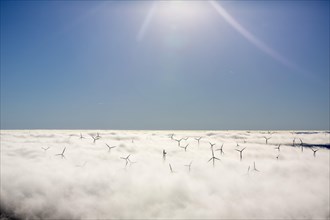 Wind turbines covered by low clouds