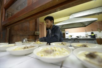 Boy working at the food counter in the kitchen of a children's home