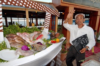 Fishmonger beckoning in a seafood restaurant