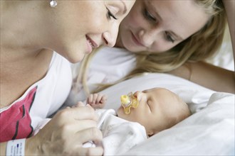 Mother in the hospital with her older daughter and a newborn baby