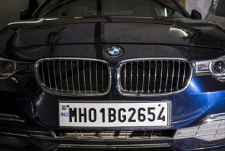The front of a German BMW car with a Maharasthra number plate