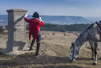 Napoleon with a telescope and horse next to his monument