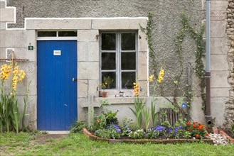Blue front door and wood window of old farmhouse in summer