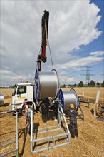 Loading of rolls of conductive cable after work on a high-voltage transmission mast