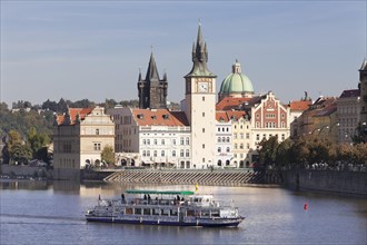 Excursion boat on the Vltava River with the Bedrich Smetana Museum and the Old Town Bridge Tower