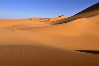 Woman walking in the dunes of In Tehak
