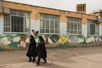 Women wearing Chador passing a kindergarten